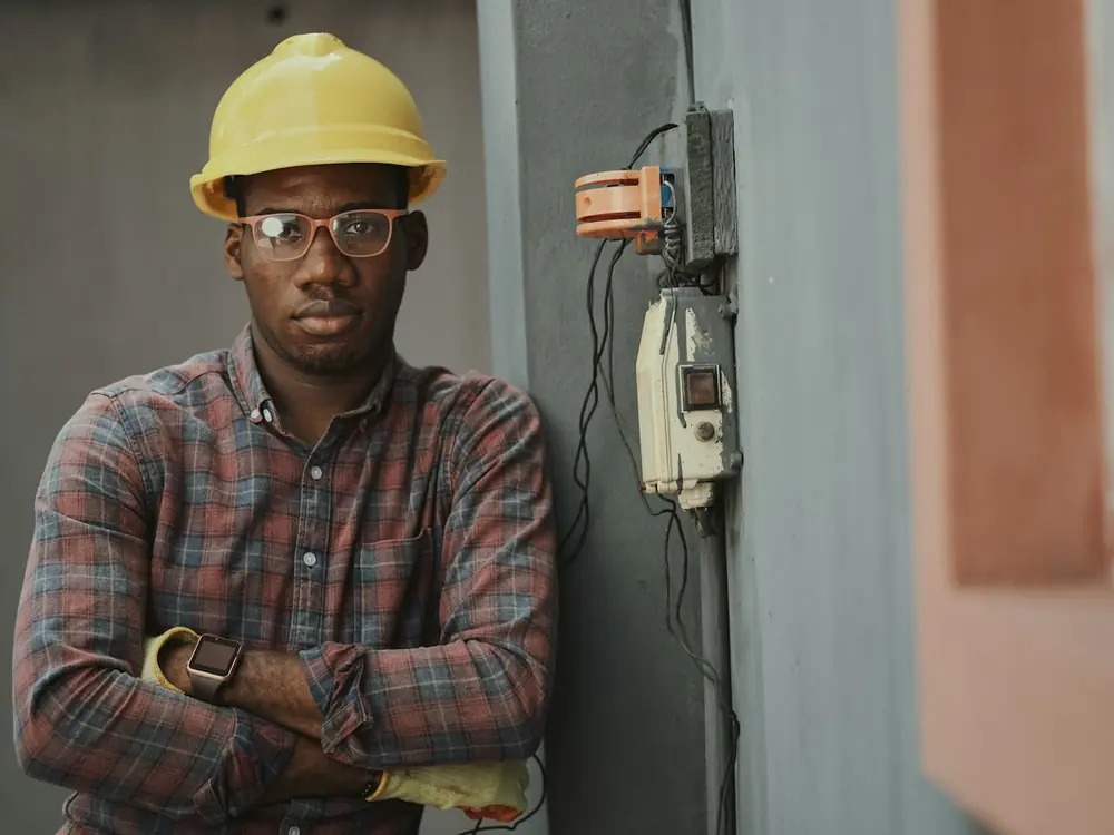Harbourline plumber in a hard hat beside plant room equipment