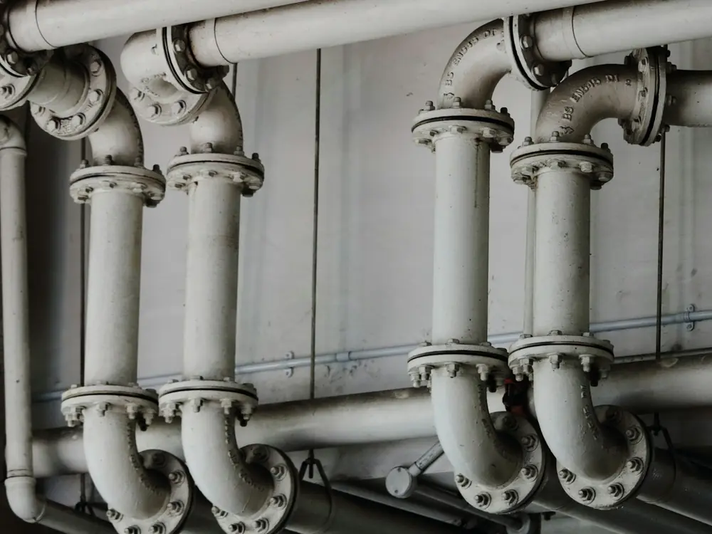 Row of large flanged riser pipes in a plant room