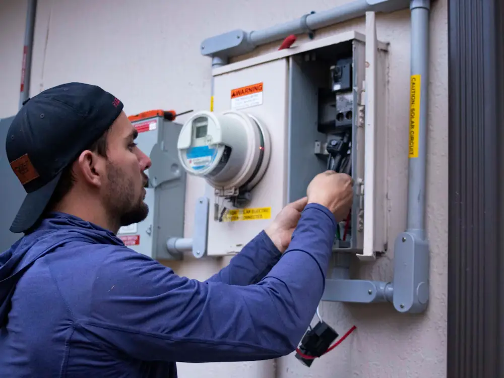 Electrician working on a meter box and main switch