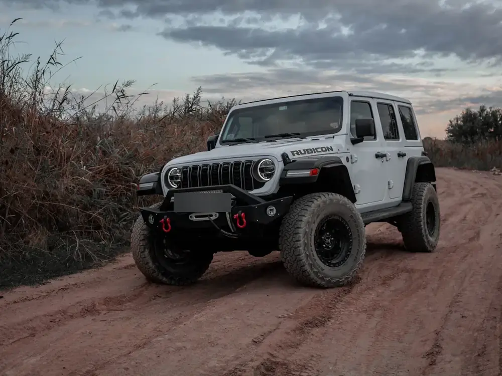 White Wrangler on big all-terrain tyres on a red dirt road
