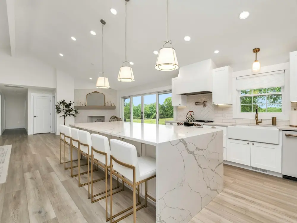 Bright kitchen with a veined marble waterfall island